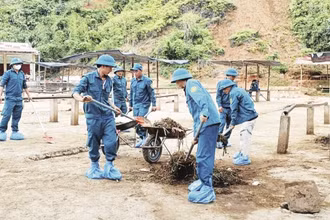 Dân quân tự vệ xã Nghiên Loan dọn dẹp, vệ sinh môi trường tại chợ trâu, bò. (Ảnh: SƠN LÂM)