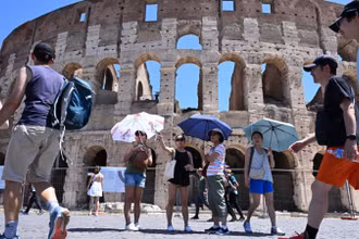 Khách du lịch che ô tránh nắng nóng khi tham quan Đấu trường La Mã ở Rome, Italia ngày 12/7/2024. (Ảnh: THX/TTXVN)