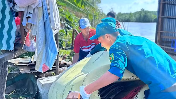 Lực lượng chức năng và đoàn thể xã Đất Mới (tỉnh Cà Mau) hỗ trợ giúp dân khắc phục hậu quả sau sạt lở đất.