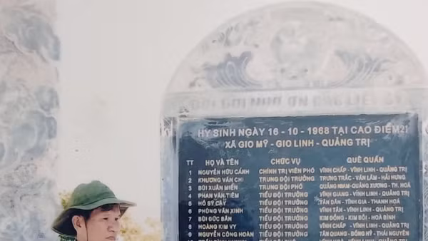 Ông Hoàng Ngọc Bích bên tấm bia ghi danh sách các đồng đội ngã xuống tại chiến trường Quảng Trị. Ảnh: NVCC