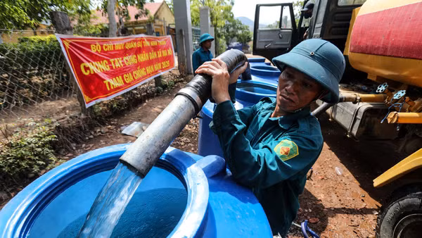 Các chiến sĩ thuộc Bộ chỉ huy Quân sự tỉnh Ninh Thuận (cũ), nay là tỉnh Khánh Hòa, mang nước sạch đến cho người dân thôn Tà Nôi. Ảnh: Thành Đạt.