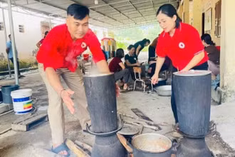 Các tình nguyện viên Chữ thập đỏ tham gia nấu cơm hỗ trợ các hộ sơ tán tại Nghệ An. 