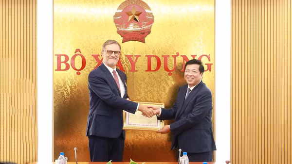 Bộ trưởng Trần Hồng Minh trao tặng Kỷ niệm chương Vì sự nghiệp Xây dựng cho Đại sứ đặc mệnh toàn quyền Cộng hòa Pháp tại Việt Nam Olivier Brochet. (Ảnh: Cổng thông tin điện tử Bộ Xây dựng)