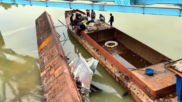 Sà-lan bị lật, mắc kẹt đã nổi trên mặt nước, được lai dắt ra khỏi gầm cầu. (Ảnh: Báo Nhân Dân)