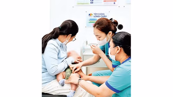 Các bậc cha mẹ tại Thành phố Hồ Chí Minh đưa trẻ đi tiêm vắc-xin phòng bệnh não mô cầu ở cơ sở tiêm chủng.