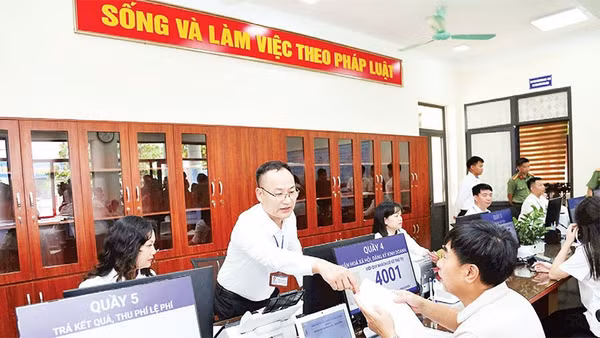 Cán bộ hướng dẫn người dân thực hiện thủ tục hành chính tại xã Phúc Thịnh, Hà Nội (Ảnh PHẠM HÙNG)