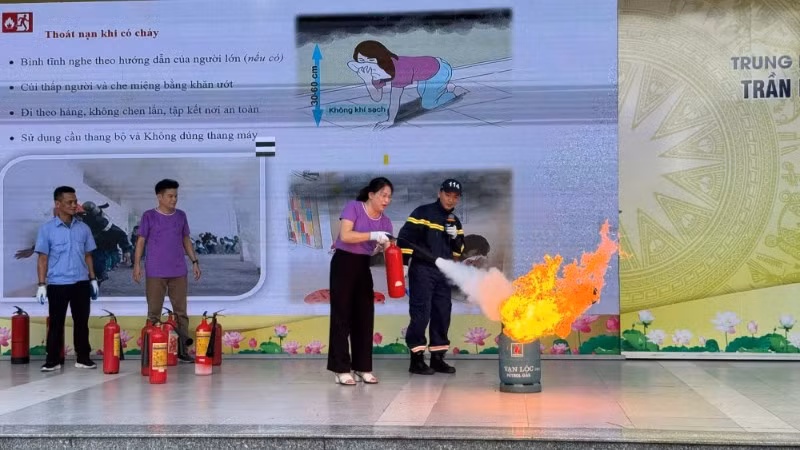Giáo viên và học sinh Trường trung học cơ sở Trần Duy Hưng, phường Yên Hòa, Hà Nội. thực hành sử dụng các loại bình cứu hỏa phù hợp khống chế các điểm cháy, đám cháy nhỏ. (Ảnh: LÊ ĐỨC-PHẠM TRUNG)