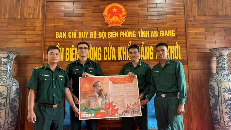 Các chiến sĩ đồn biên phòng cửa khẩu cảng An Thới vui mừng đón nhận phụ san đặc biệt của báo Nhân Dân.