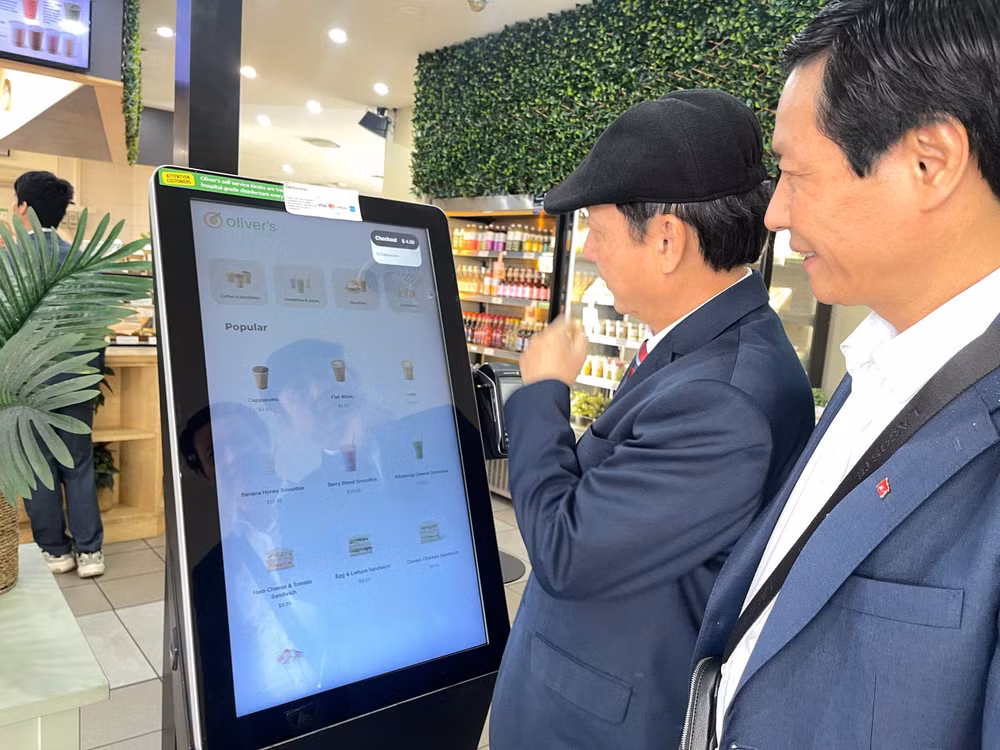 Đoàn cán bộ chương trình bồi dưỡng ngắn hạn tại Australia trải nghiệm thanh toán số tại một cửa hàng ở thủ đô Canberra (Australia)