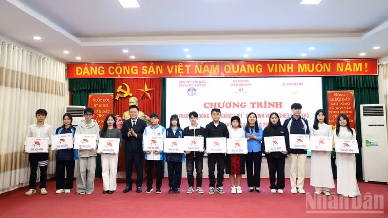 Đồng chí Phan Văn Hùng, Phó Tổng Biên tập Báo Nhân Dân và đồng chí Lê Thị Thanh Trà, Phó Chủ tịch Hội đồng nhân dân tỉnh Tuyên Quang trao học bổng cho các sinh viên nghèo vượt khó.