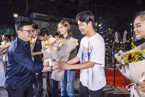 Tổng Biên tập Báo Nhân Dân Lê Quốc Minh tặng hoa cho các ca sĩ biểu diễn tại chương trình. (Ảnh: THÀNH ĐẠT)