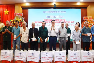 Đồng chí Nguyễn Trọng Nghĩa trao quà và hoa tri ân các gia đình chính sách.