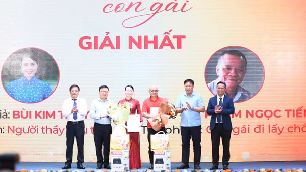 Nhà báo Lê Quốc Minh, Ủy viên Trung ương Đảng, Tổng Biên tập Báo Nhân Dân, Phó Trưởng Ban Tuyên giáo Trung ương, Chủ tịch Hội Nhà báo Việt Nam cùng đại diện Ban Tổ chức cuộc thi trao giải Nhất cho hai tác giả. (Ảnh: Ban Tổ chức)