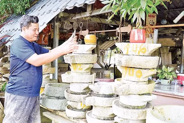 Ông Lê Văn Dũng thao tác quay cối xay bột quen thuộc, tái hiện lại nét sinh hoạt văn hóa ẩm thực dân gian xưa.