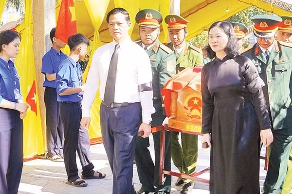 Các đại biểu tiễn đưa các liệt sĩ về nơi an nghỉ (Ảnh HIẾU MINH)