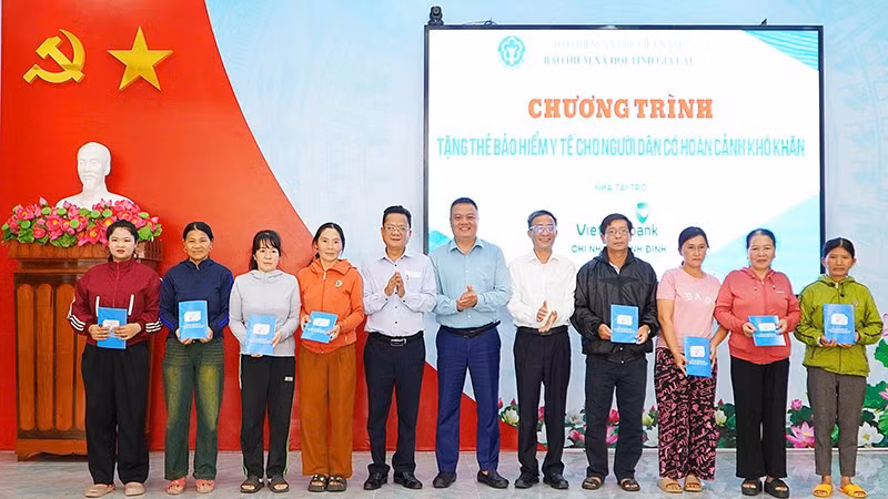 Các đại biểu trao tặng thẻ bảo hiểm y tế cho người dân có hoàn cảnh khó khăn. (Ảnh: BTC)