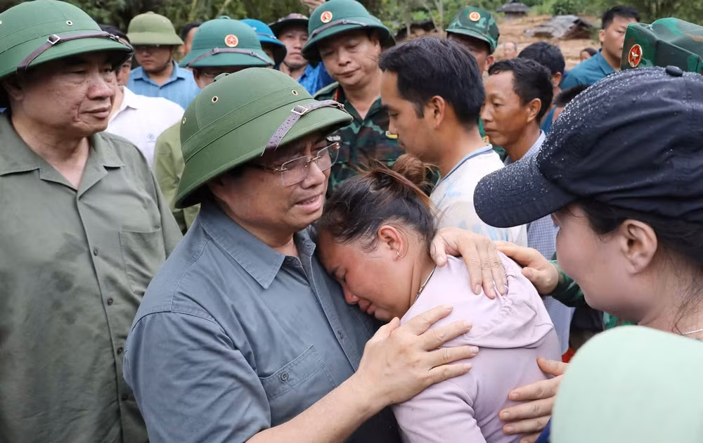 Thủ tướng chia sẻ với nỗi đau mất người thân của người dân vùng lũ quét. (Ảnh TTXVN)