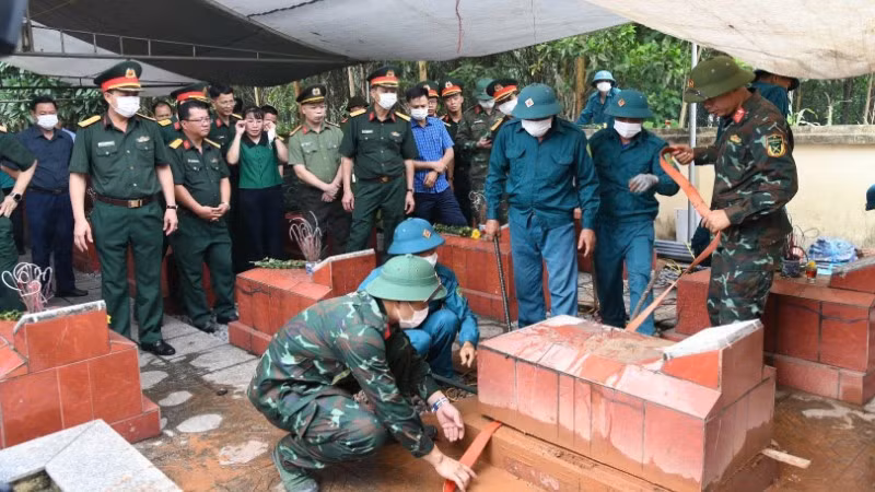 Các lực lượng tiến hành lấy mẫu tại nghĩa trang liệt sĩ Yên Trạch. (Ảnh: THIỀU CHUNG)