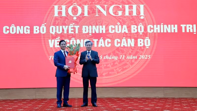 Đồng chí Nguyễn Quang Dương, Phó Trưởng ban Tổ chức Trung ương (bên phải) trao quyết định và tặng hoa chúc mừng đồng chí Vương Quốc Tuấn. (Ảnh: TUẤN SƠN)
