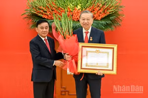 Thường trực Ban Bí thư Trần Cẩm Tú trao huy hiệu 45 năm tuổi đảng, tặng hoa chúc mừng đồng chí Tô Lâm, Tổng Bí thư Ban Chấp hành Trung ương Đảng Cộng sản Việt Nam. (Ảnh: DUY LINH)