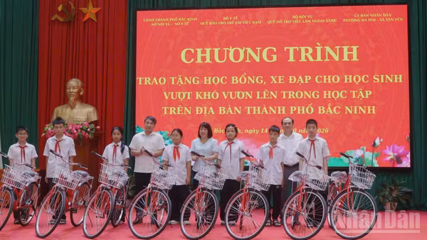 Các đại biểu trao tặng xe đạp cho các học sinh tại chương trình. (Ảnh NGÂN ANH)