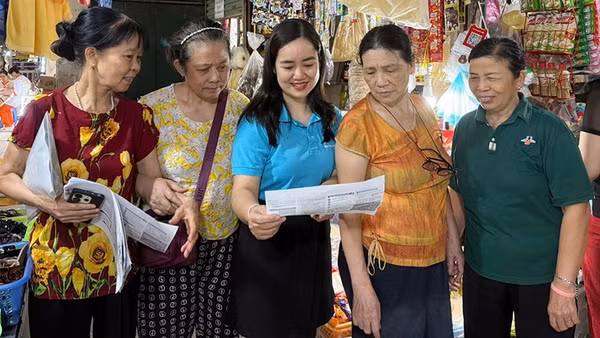 Cán bộ Bảo hiểm xã hội Hà Nội vận động người dân tham gia bảo hiểm xã hội tự nguyện, bảo hiểm y tế hộ gia đình. (Ảnh HSS)