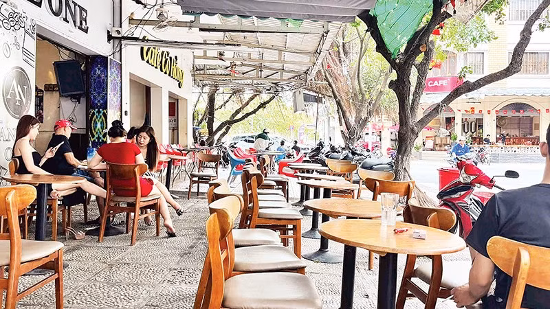 Các quán cà-phê trên đường Vũ Huy Tấn, phường Gia Định lấy luôn vỉa hè để buôn bán, đẩy người đi bộ xuống lòng đường.