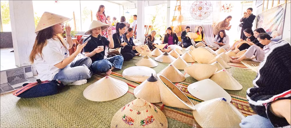 Du khách tham quan, tìm hiểu nghề làm nón ngựa Phú Gia.
