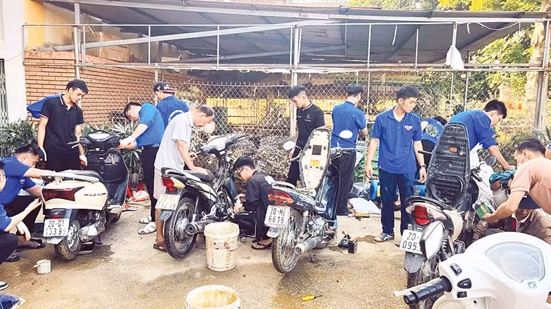 Sinh viên tình nguyện Trường đại học Điện lực sửa chữa xe máy cho người dân Thái Nguyên.