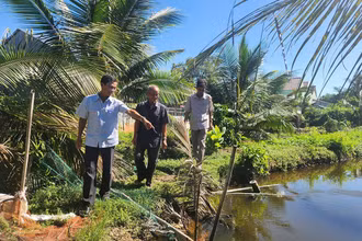 Ông Năm Dậu (giữa) cùng cán bộ địa phương đến tận nơi tìm hiểu, giải quyết ổn thỏa mâu thuẫn trong tranh chấp đất của hai hộ dân.