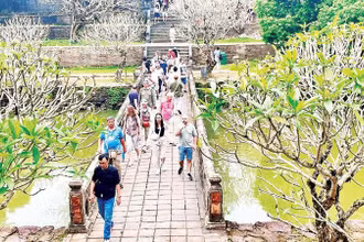Du khách quốc tế tham quan một điểm di tích tại Huế.