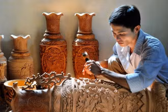 Người thợ chạm khắc gỗ tại làng nghề truyền thống Vân Hà (Hà Nội).
