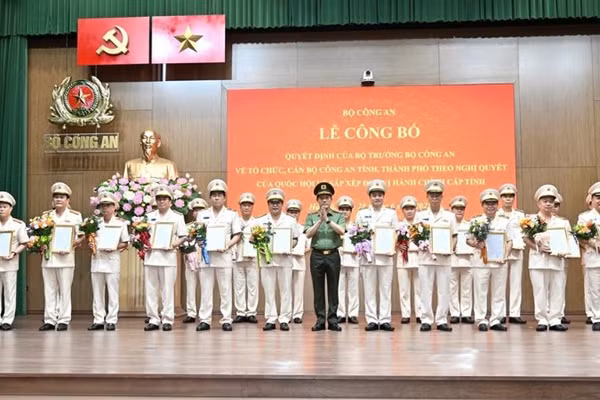 Bộ trưởng Lương Tam Quang trao Quyết định và tặng hoa chúc mừng các đồng chí Giám đốc Công an địa phương sau sáp nhập.