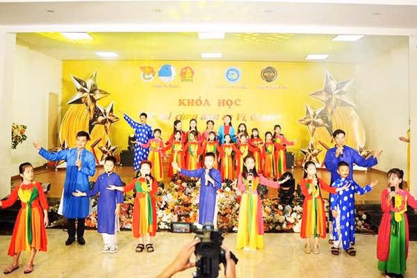 Nghệ nhân Văn Sang (đứng bên trái) dạy các em nhỏ khóa học về dân ca ví, giặm. Ảnh: NVCC