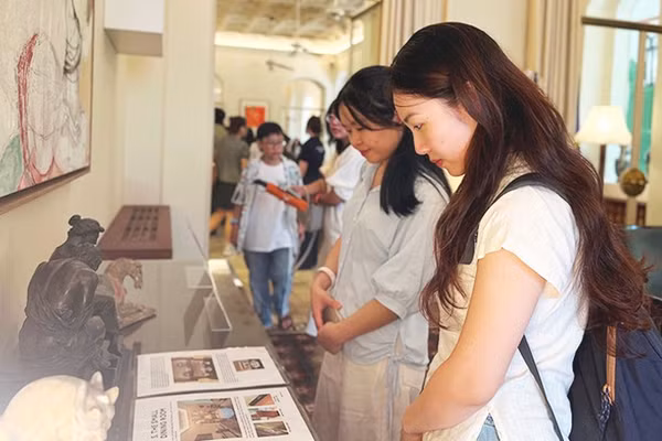 Khách tham quan tìm hiểu các hiện vật trưng bày tại Dinh thự Pháp.