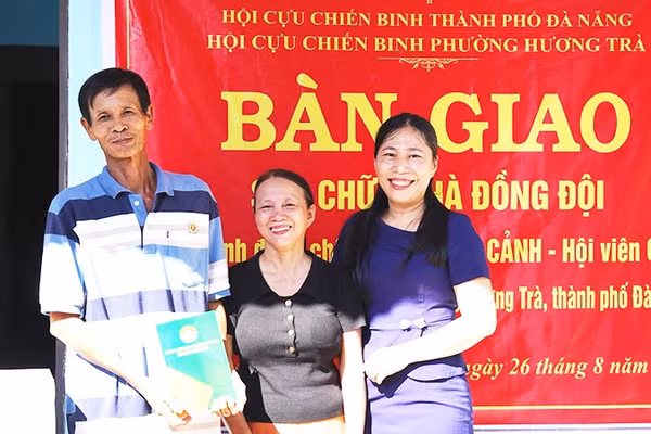 Cựu chiến binh Trương Văn Cảnh, phường Hương Trà (bên trái), nhận bàn giao mái ấm nghĩa tình từ đồng đội. 
