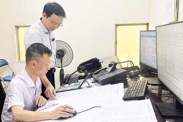 Anh Vũ Đình Thành (ngồi), nhân viên Trung tâm Điều hành vận tải đường sắt (Tập đoàn Đường sắt quốc gia Việt Nam), trong ca trực điều độ chạy tàu tuyến Vinh-Đồng Hới.