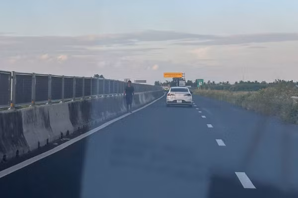 Người đi bộ băng qua làn đường cao tốc Lộ Tẻ-Rạch Sỏi tiềm ẩn nguy cơ tai nạn giao thông. ( Ảnh: Thanh Dũng)