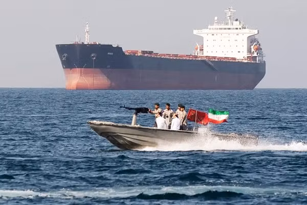 Xuồng vũ trang của Iran hoạt động gần một tàu hàng ở Eo biển Hormuz. Ảnh: AP
