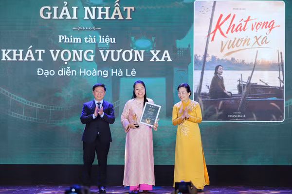 Phó Trưởng ban Thường trực Ban Tuyên giáo Trung ương Trần Thanh Lâm và Chủ tịch Hiệp hội Xúc tiến phát triển Điện ảnh Việt Nam Ngô Phương Lan trao giải nhất cho tác giả Hoàng Hà Lê. (Ảnh: VIỆT HÙNG/MCST)