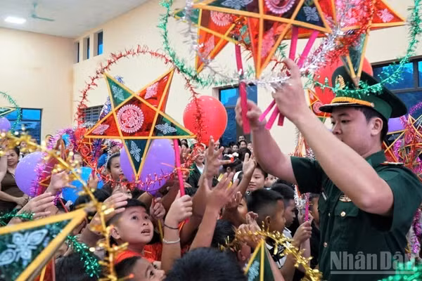 Các em nhỏ háo hức đón lấy chiếc đèn ông sao năm cánh truyền thống. 