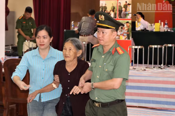Lực lượng Công an và cán bộ xã Giai Lạc hỗ trợ thân nhân liệt sĩ đến điểm thu nhận mẫu ADN.