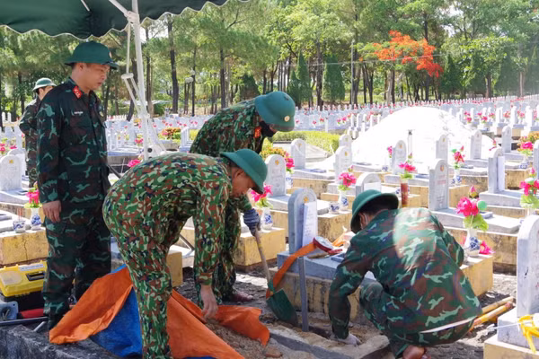 Thành viên Đội 584 (Bộ Chỉ huy quân sự tỉnh Quảng Trị) lấy mẫu để giám định ADN ở phần mộ liệt sĩ chưa xác định được thông tin. (Ảnh HIẾU MINH)