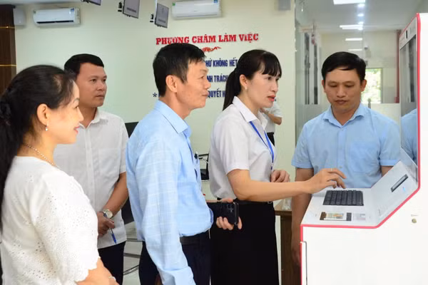 Cán bộ Trung tâm Phục vụ hành chính công phường Hàm Rồng, tỉnh Thanh Hóa hỗ trợ, hướng dẫn sử dụng kiosk thông minh trong triển khai thủ tục hành chính công. (Ảnh: MINH CHÍNH)