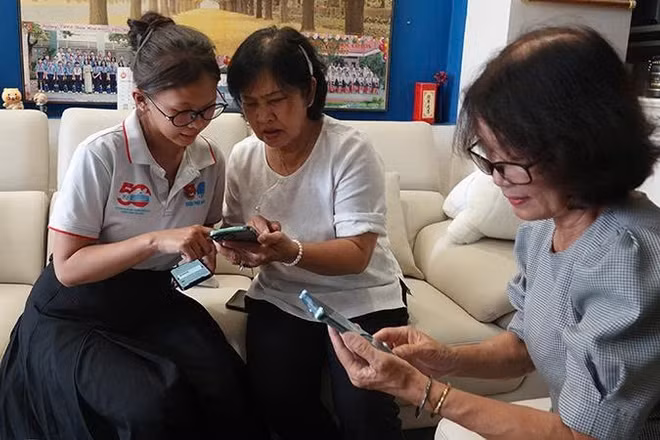 Chi bộ khu phố 2, Đảng ủy phường Đức Nhuận phối hợp Tổ công nghệ số cộng đồng khu phố 2 hướng dẫn đảng viên sử dụng Sổ tay đảng viên điện tử. (Ảnh: MẠNH HẢO)