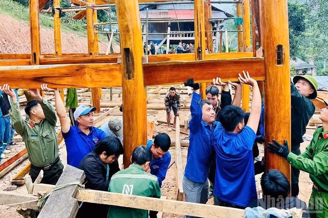 Lực lượng công an và các tổ chức đoàn thể hỗ trợ người dân xã biên giới Nhôn Mai dựng nhà mới sau thiên tai (Ảnh: PHAN TUYẾT)
