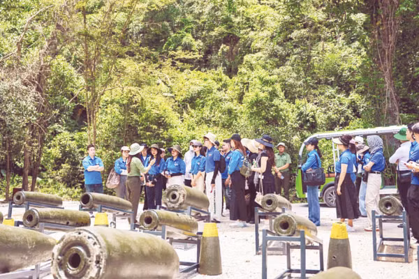 Du khách tham quan khu trưng bày chứng tích bom mìn ngoài trời tại Hang Chỉ Huy.
