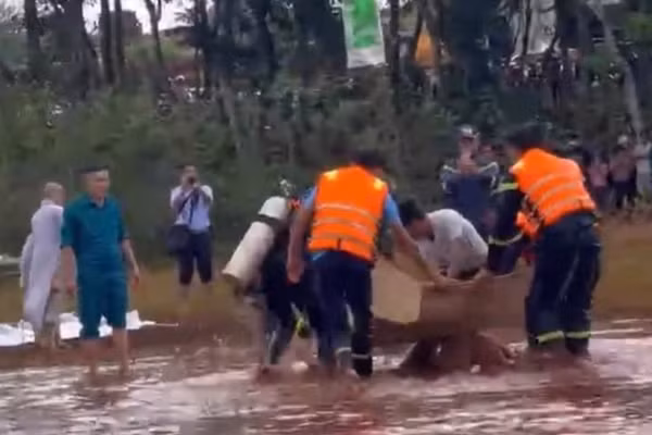 Lực lượng chức năng đưa thi thể nạn nhân vào bờ. (Ảnh: NS)