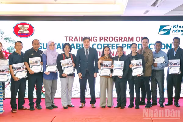 Giám đốc Trung tâm Khuyến nông quốc gia Lê Quốc Thanh trao chứng nhận và ảnh lưu niệm cho các học viên tham gia lớp tập huấn. (Ảnh: BẢO VĂN)