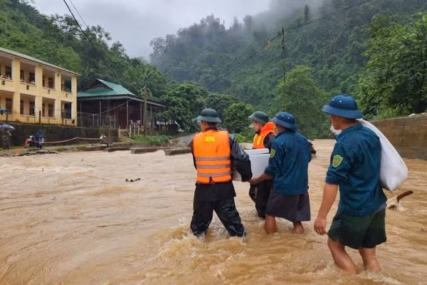 Cán bộ, chiến sĩ Đồn Biên phòng Tam Hợp và Ban Chỉ huy quân sự xã Tam Thái, tỉnh Nghệ An, đưa cơm cho học sinh điểm trường bán trú bị mưa lũ chia cắt. (Ảnh: TRUNG HIẾU)